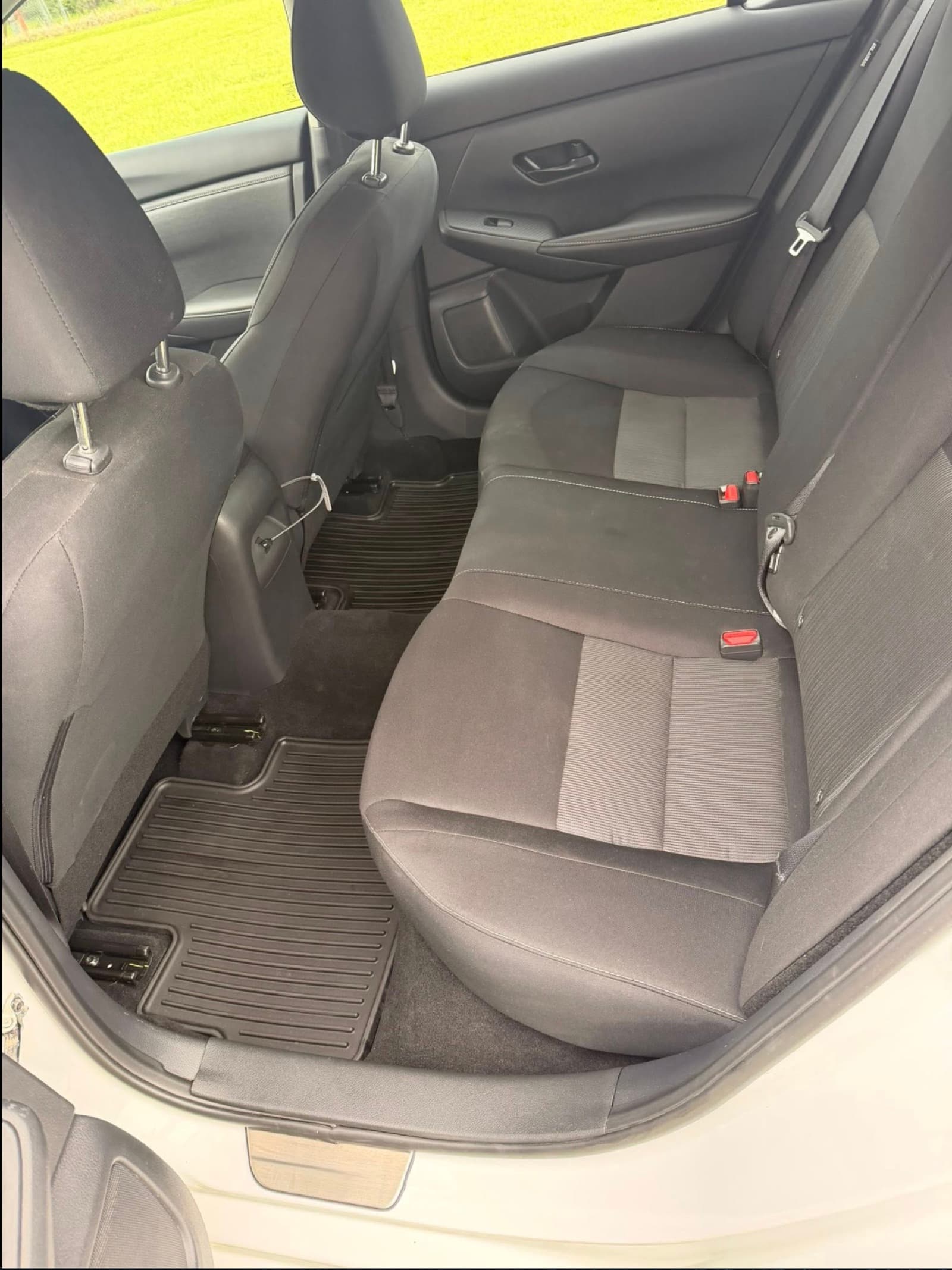 Sedan rear interior after detailing — clean seats and fresh rubber floor mats.