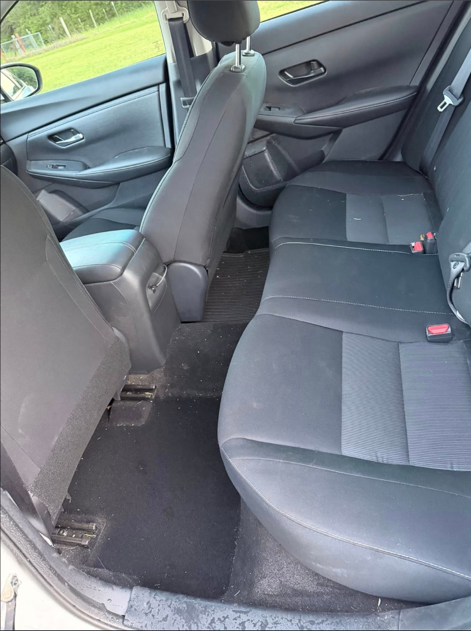 Sedan rear interior before detailing — dirty floor and worn-looking seats.